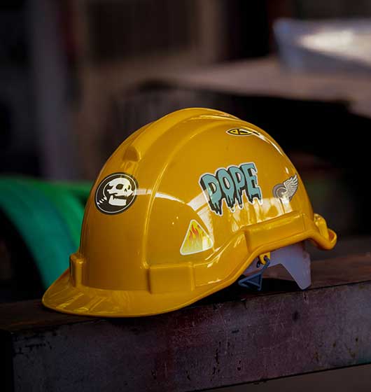 Hard hat with stickers in construction scenery